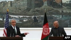 U.S. Secretary of Defense Chuck Hagel (left) gestures while speaking during a joint news conference with Afghan President Ashraf Ghani at the Presidential Palace in Kabul on December 6.