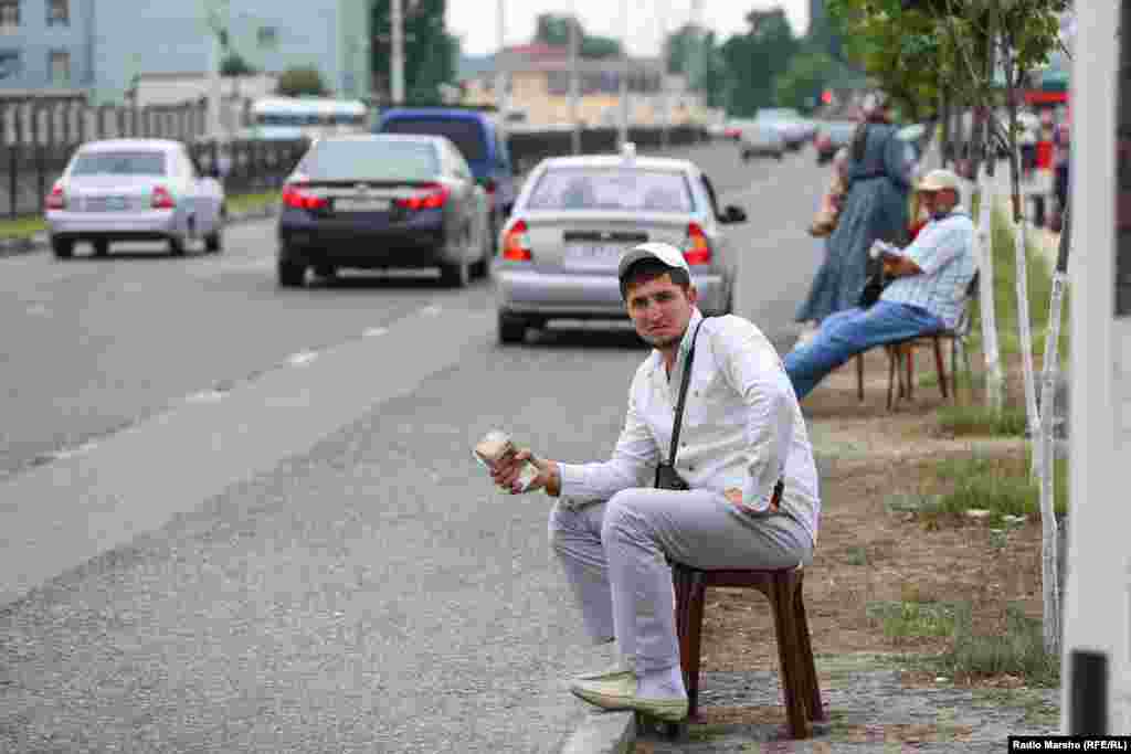 A streetside money changer waits for customers.