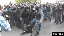 Кадр из видеоролика, на котором сотрудник ОМОНа бьет ногой женщину. 6 мая 2012 года