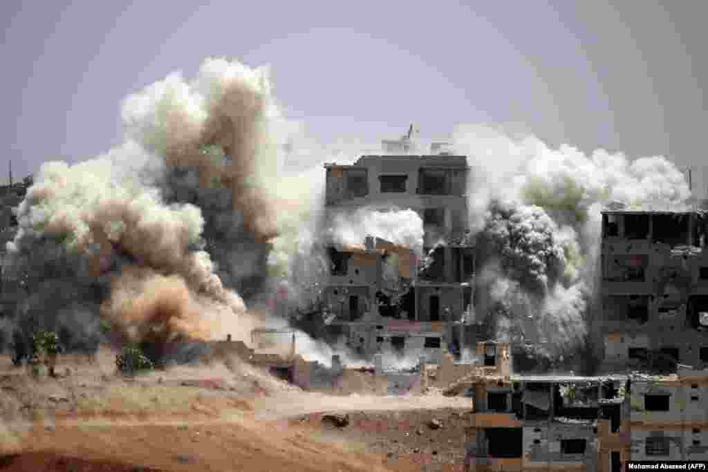 Smoke rises around buildings following a reported air strike on a rebel-held area in the southern Syrian city of Daraa. (AFP/Mohamad Abazeed)