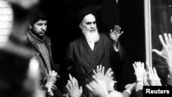 The leader and founder of the Islamic revolution, Ayatollah Ruhollah Khomeini, waves from a Tehran balcony during the country's revolution, in February 1979.