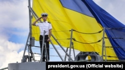 Матрос ВМС на фоне огромного флага Украины на фрегате «Гетман Сагайдачный» во время учений «Си Бриз-2018». Одесса, 16 июля 2018 года