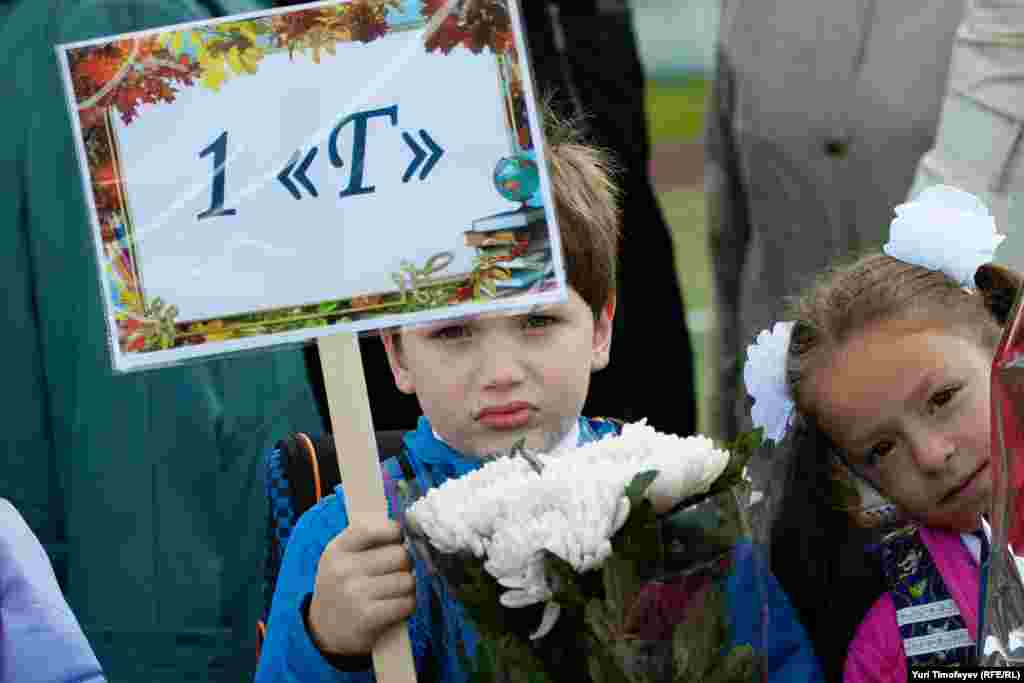 Mikhail Timofeyev, 7, holds up a first-grade placard at an opening-day ceremony at School No. 1507 in Moscow.&nbsp; 