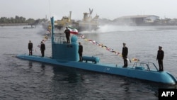 An Iranian Qadir light submarine and a hovercraft move in Persian Gulf waters in late November.