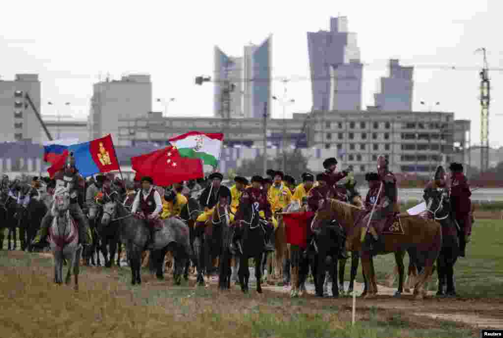 Riders from several of the nine teams competing in the kokpar championships parade on the field during the opening ceremony of the kokpar championship in Astana on September 11, 2013.