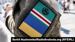 Під час акції «Ічкерія жива!». Київ, майдан Незалежності, 13 серпня 2017 року. На фото – член одного з чеченських батальйонів із нашивками прапорів Ічкерії та України