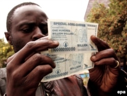 2008: Egy zimbabwei férfi két, százmilliárd dolláros bankjeggyel. Az országban ismét súlyos a drágulás, az emberek az amerikai dollárban hisznek