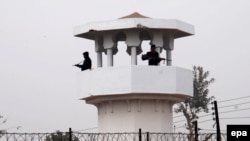 Pakistani police stand guard in the watch tower of central jail in Faisalabad city after government lifted a six-year moratorium on executions.