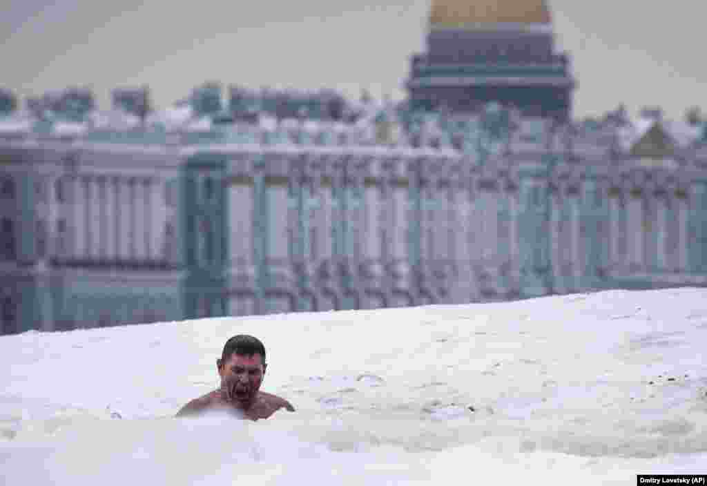 Newa derýasyndaky buz deşiginde suwa düşýän adam. Sankt-Peterburg, Russiýa. (AP/Dmitri Lovetsky)