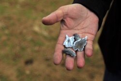 A man holds shrapnel believed to be from a missile launched by Iran on U.S.-led coalition forces on the outskirts of Duhok, Iraq, on January 8.