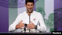 Serbia’s Novak Djokovic talks to the press after beating Roger Federer on July 14 to claim his fifth Wimbledon title. 