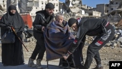 An elderly Syrian man is carried during an evacuation operation of rebel fighters and their families from rebel-held neighborhoods in the embattled city of Aleppo on December 15.