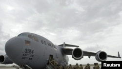 U.S. servicemen board a plane bound for Afghanistan at the U.S. transit center at Manas airport in April 2011.