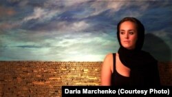 Художниця Дарія Марченко на тлі своєї роботи