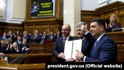 Зліва направо: спікер парламенту Андрій Парубій, президент Петро Порошенко і прем’єр-міністр Володимир Гроймсан на трибуні Верховної Ради з підписаним главою держави законом про зміни до Конституції, які закріплюють курс України на ЄС і НАТО. Київ, 19 лютого 2019 року