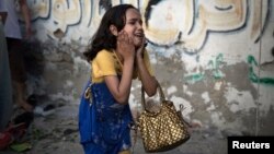 A Palestinian girl reacts at the scene of an explosion that medics said killed eight children and two adults, and wounded 40 others at a public garden in Gaza City on July 28.