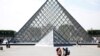 FRANCE - FILE PHOTO: Tourists stand in front of the Louvre Pyramid designed by Chinese-born U.S. Architect Ieoh Ming Pei in Paris, France, September 13, 2016