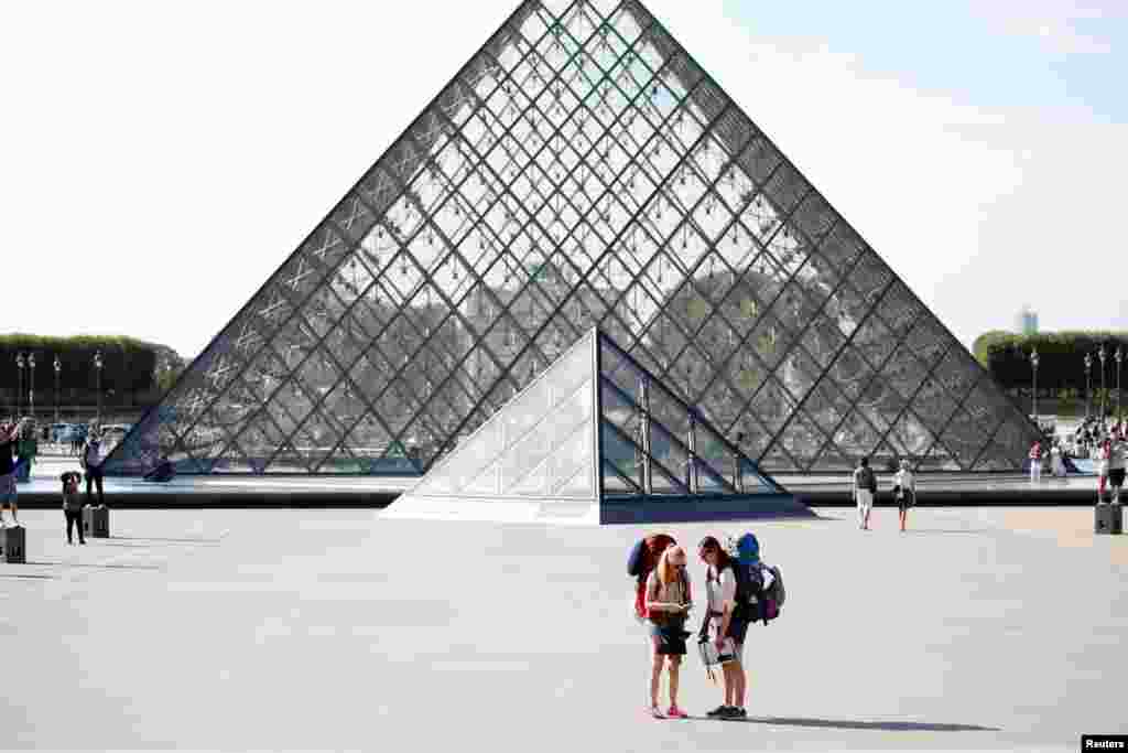 FRANCE - FILE PHOTO: Tourists stand in front of the Louvre Pyramid designed by Chinese-born U.S. Architect Ieoh Ming Pei in Paris, France, September 13, 2016