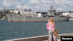 Ресейдің әскери-теңіз кемесін суретке түсіріп тұрған әйел. Севастополь, 6 қыркүйек 2013 жыл. (Көрнекі сурет)