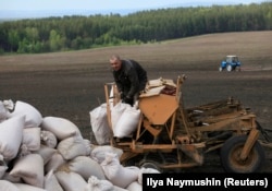 An inmate loads barley into a seeder at a penal colony some 40 kilometers northeast of the Siberian city of Krasnoyarsk.