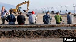 Рабочие во время перекура на одном из объектов олимпийской стройки. Сочи, 26 января 2014 года.