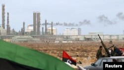 A Kingdom of Libya flag placed in front of a refinery in Ras Lanuf on March 8