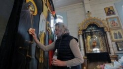 Служниця у православній церкві дезінфікує поверхню ікони. Білорусь. Березень 2020 року