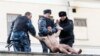 Сотрудники МВД задерживают Петра Павленского после того, как он отрезал часть мочки уха, сидя на стене, окружающей Институт судебной психиатрии имени Сербского в рамках акции протеста "Сегрегация" 