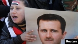 President Bashar al-Assad supporters attend a rally in Damascus on January 20.