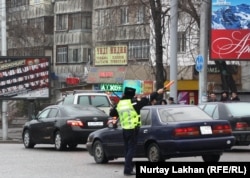 Алматыдағы жол жүрісін реттеп тұрған жол полициясы инспекторы.