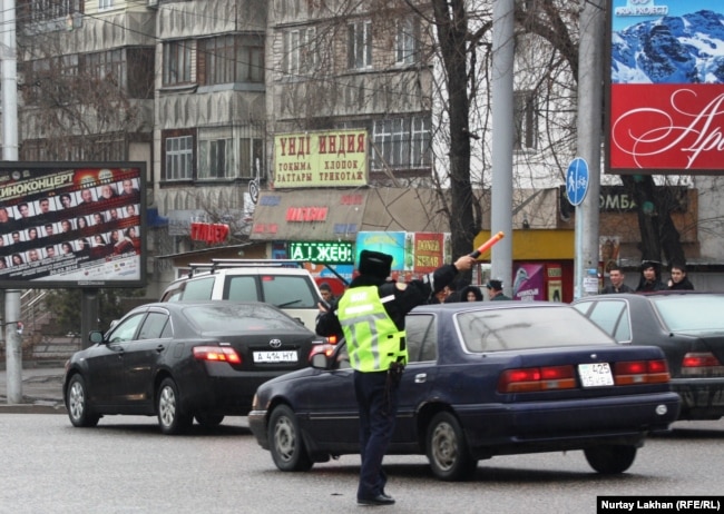 Алматыдағы жол жүрісін реттеп тұрған жол полициясы инспекторы.