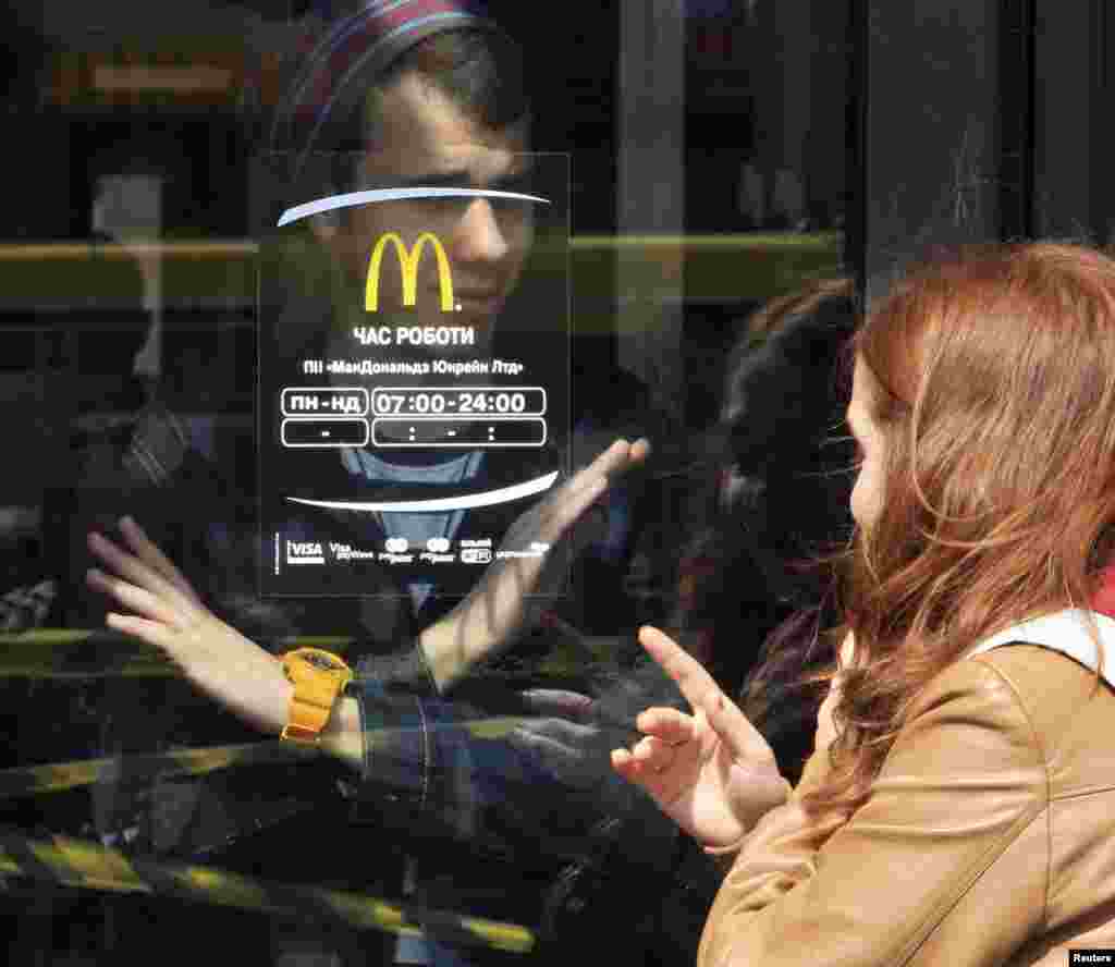 A man signals to a woman that the McDonald&#39;s restaurant is closed in the Crimean city of Simferopol. (Reuters)