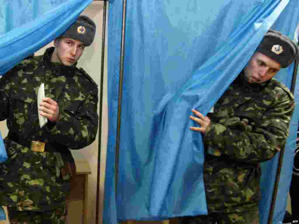 Ukrainian soldiers from the Presidential Regiment exit voting booths at a polling station in the capital.