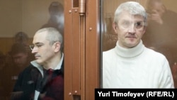 Mikhail Khodorkovsky (left) with Platon Lebedev inside the bullet-proof glass defendents' cage of a Moscow court.