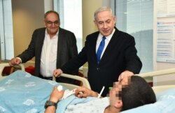 Зеев Ротштейн (слева) и Биньямин Нетаньяху посещают раненых израильских солдат в клинике "Адаса"