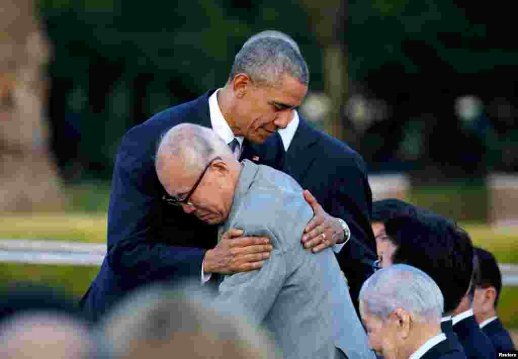 ABŞ-nyň prezidenti Barak Obama Hiroşima parahatçylyk memorialyna baranda Hiroşima atom bombasy taşlananda aman galan Şigeaki Mori bilen gujaklaşýar. Ýaponiýa. (Reuters/Carlos Barria)