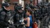 Журналістка задае пытаньне паліцыянту падчас пратэсту 17 ліпеня, напярэдадні зьезду рэспубліканцаў у Кліўлэндзе.