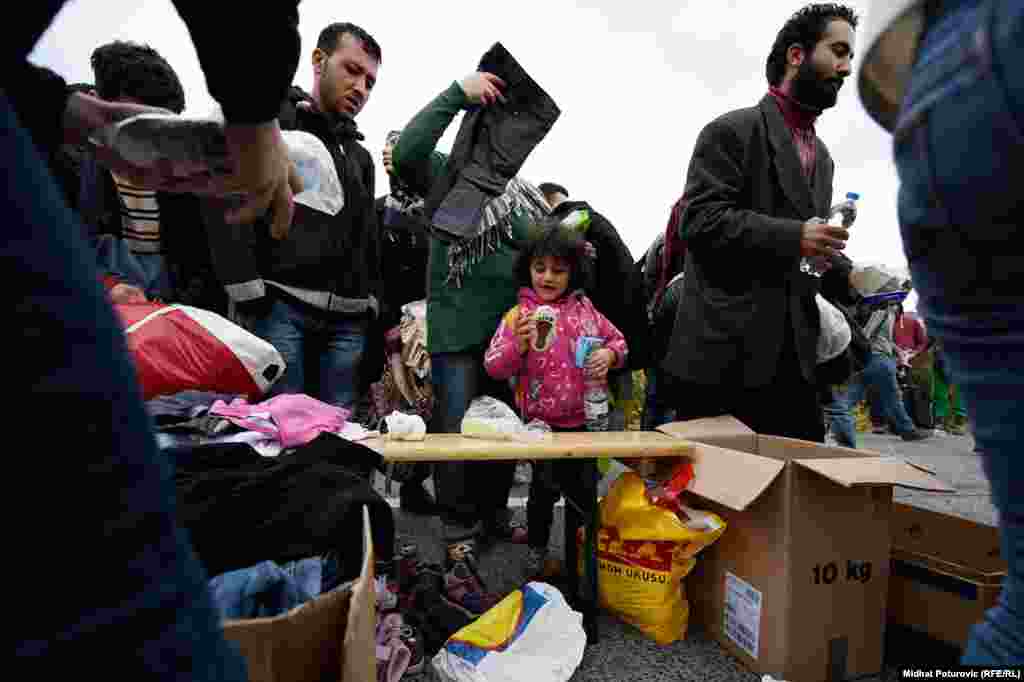 Izbjeglice uzimaju odjeću koju su za njih pripremili volonteri