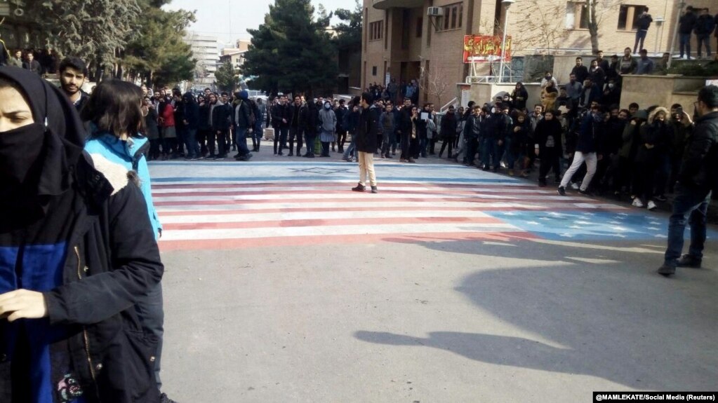 Students walk around, instead of across, U.S. and Israeli flags at the Shahid Beheshti University in Tehran on January 12. 