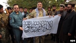 Военные армии Афганистана показывают флаг, оставленный боевиками "Талибана"