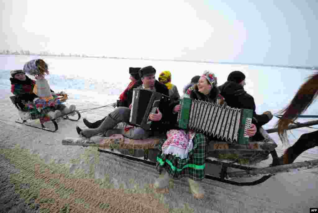 A man and a woman play their accordions and sing as they ride a horse-drawn sleigh celebrating the Kolyada holiday, an ancient, pre-Christian winter festival, in Martsiyanauka, some 110 kilometers east of Minsk, Belarus. (AFP/Sergei Gapon)