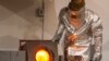 A worker wearing a heatproof suit pours molten gold in a workshop of the Altyntau extraction plant.