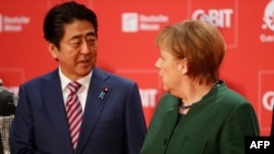 Канцлер Німеччини Ангела Меркель (п) і прем'єр-міністр Японії Сіндзо Абе на відкритті виставки технологій CeBIT в Ганновері, Німеччина, 19 березня 2017 року