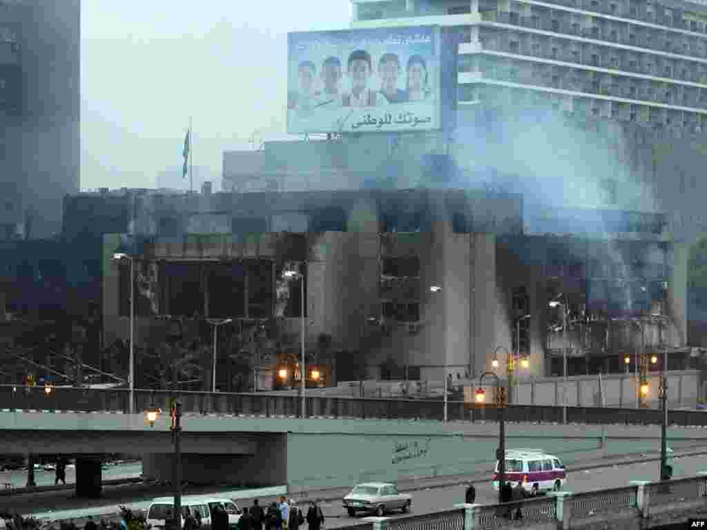 Smoke rises from the burned-out headquarters of the ruling National Democratic Party (NDP) in Cairo on January 29.