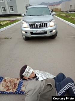 77-летний житель ВКО Владимир Тарасов проводит "лежачую" акцию протеста на въезде на территорию областного суда. Усть-Каменогорск, 8 октября 2018 года.