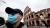 Турист носи заштитна маска пред Колосеумот во Рим, Италија.