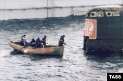 A group of workers approach the conning tower of the Kursk submarine, which was raised from the seafloor in 2001.