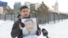Байболат Кунболатулы с портретом младшего брата, который, по утверждениям Байболата, был осужден в Китае по надуманным обвинениям. Нур-Султан, февраль 2020 года.