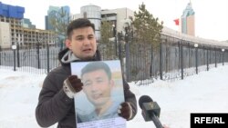 Байболат Кунболатулы перед посольством Китая в Нур-Султане с портретом младшего брата, заключенного в китайской тюрьме. 20 февраля 2020 года. 
