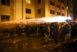 Police use a water cannon against demonstrators as they try to block the entrances to parliament in Tbilisi on November 26.